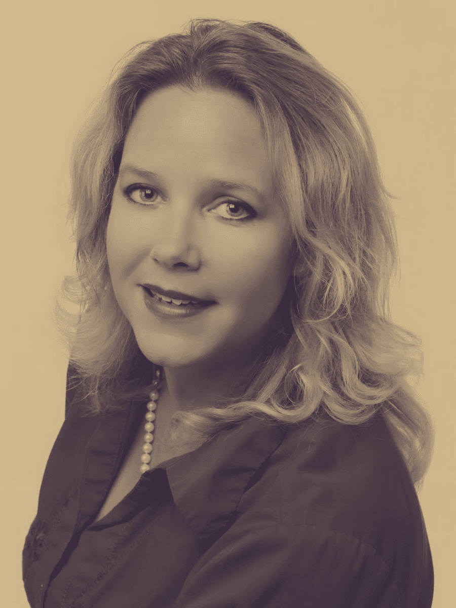 Sepia-toned portrait of a smiling woman with wavy blonde hair wearing a pearl necklace.